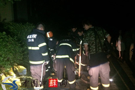 消防官兵正在對(duì)跌落窯井后的物業(yè)人員進(jìn)行救援